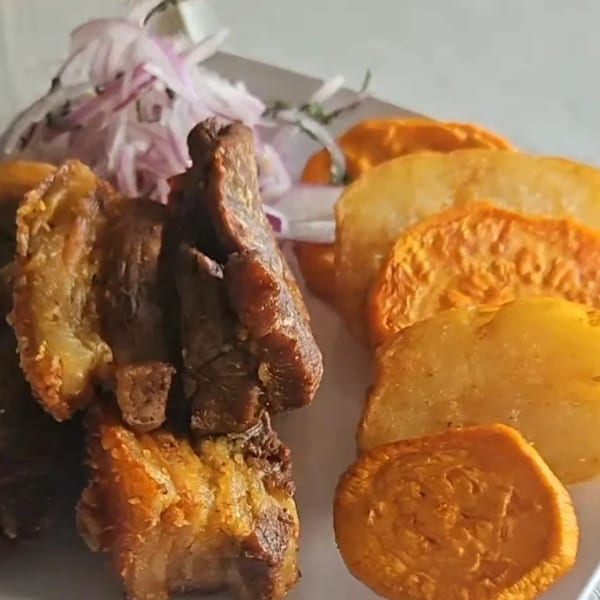 Crispy Peruvian chicharrón with golden fried sweet potato slices and red onion relish.
