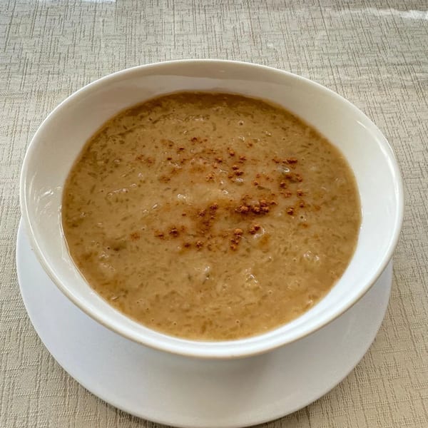 A Peruvian arroz con leche dessert, a creamy rice pudding topped with cinnamon, in a white bowl.