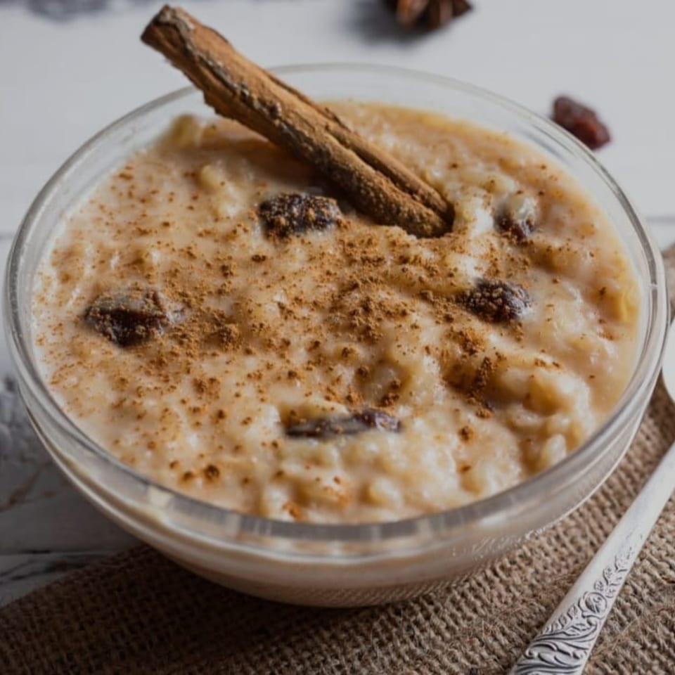 Peruvian arroz con leche dessert in a glass bowl, topped with cinnamon and raisins.